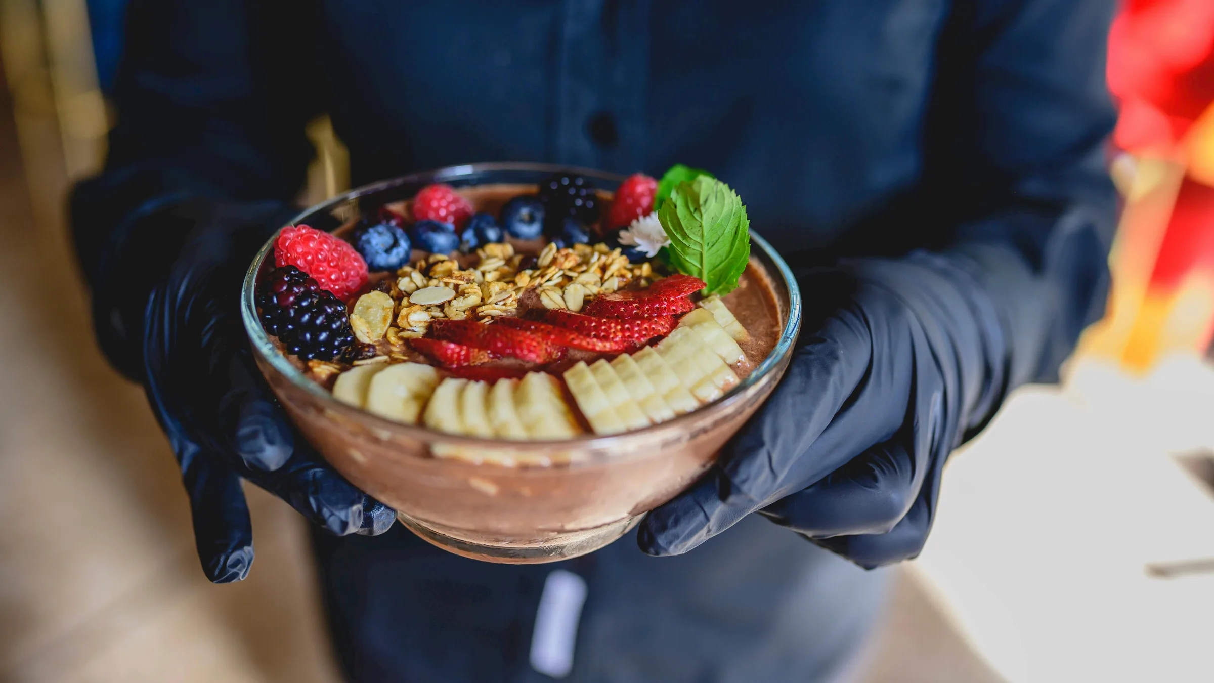 Açaí bowl blended thick with granola, strawberries and banana at Phat's Kitchen Miami — spoon standing upright in the base