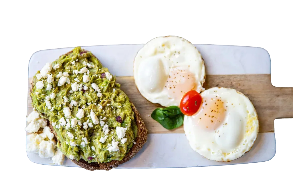 Avocado toast with fried eggs on a wood board